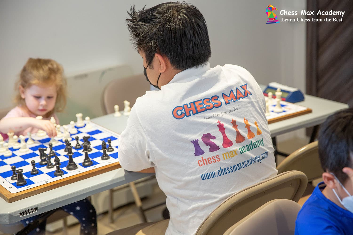 Young chess students working with a Chess Max coach