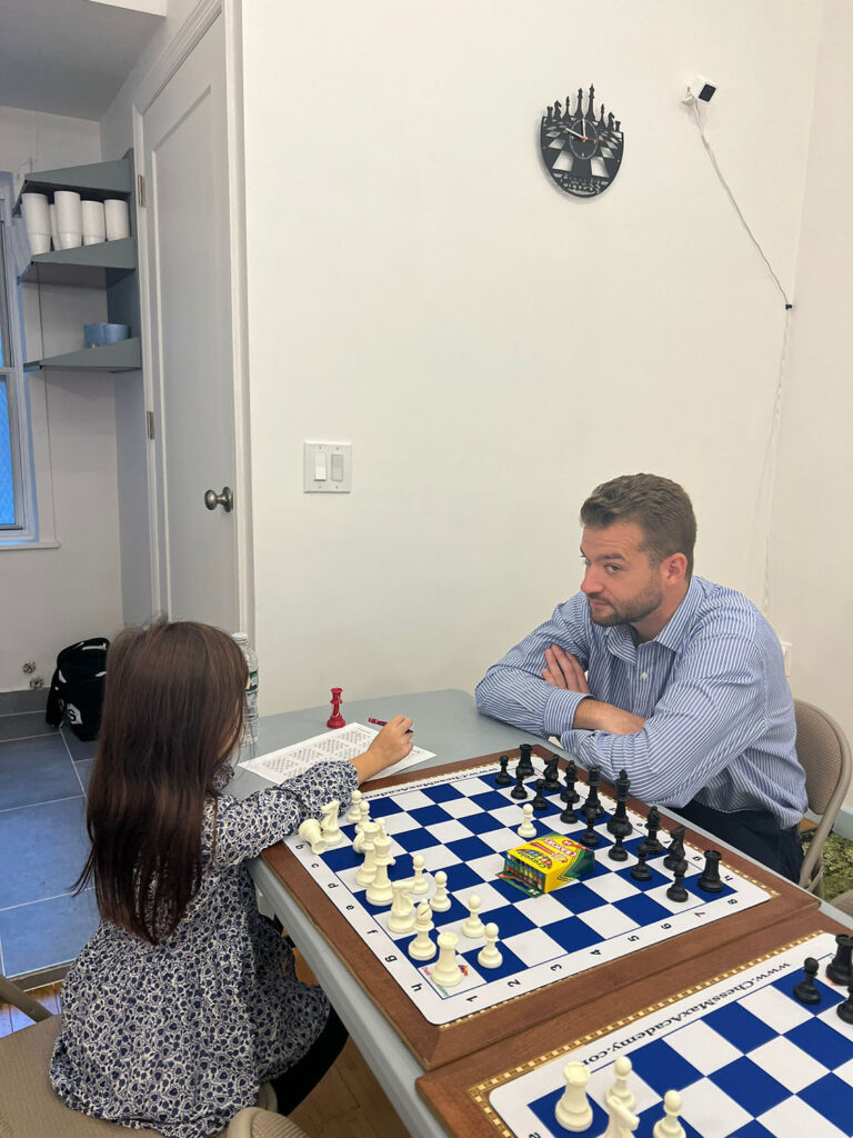 Coach and student reviewing a chess position at Chess Max Academy
