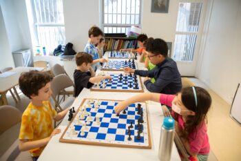 Chess coach working with children at Chess Max Academy NYC