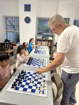 Chess coach teaching children during a kids chess class in NYC