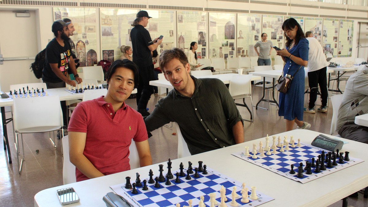 Busy chess event room with players at multiple boards