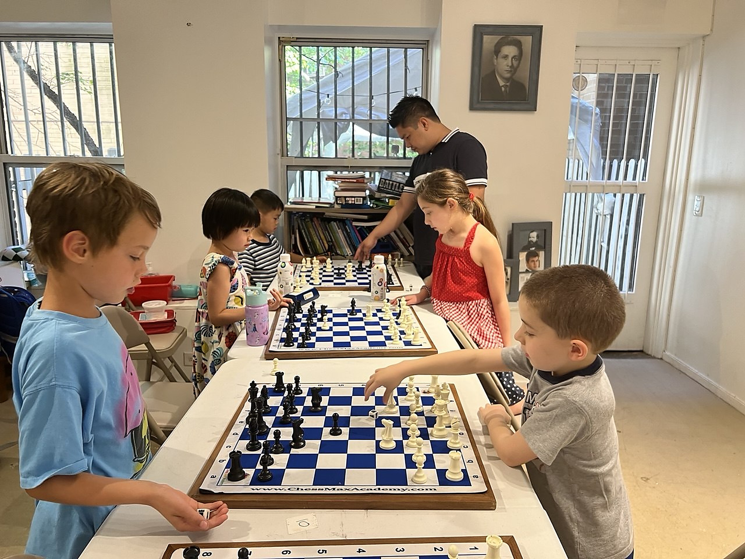 Young students playing chess during a group chess class at Chess Max Academy, developing strategy, focus, and tournament skills.