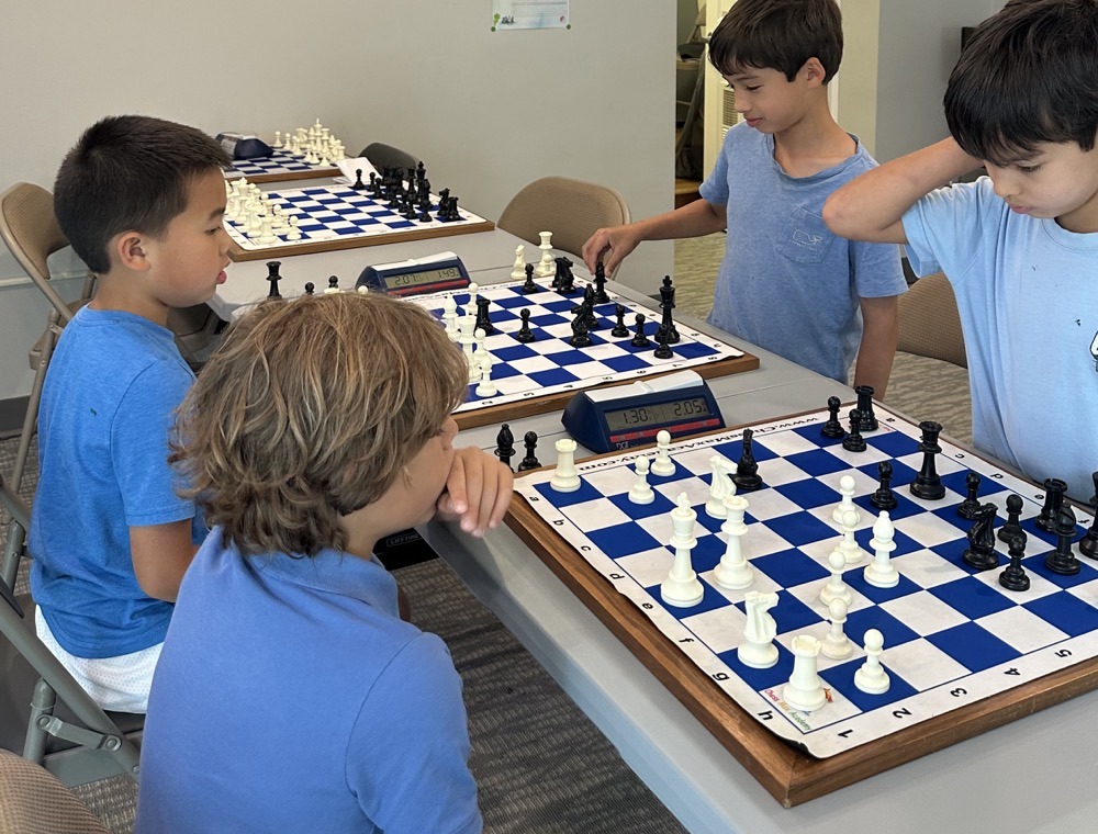 Campers working through practice games with chess clocks