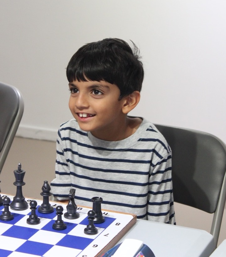 Camper smiling during a chess activity at summer camp