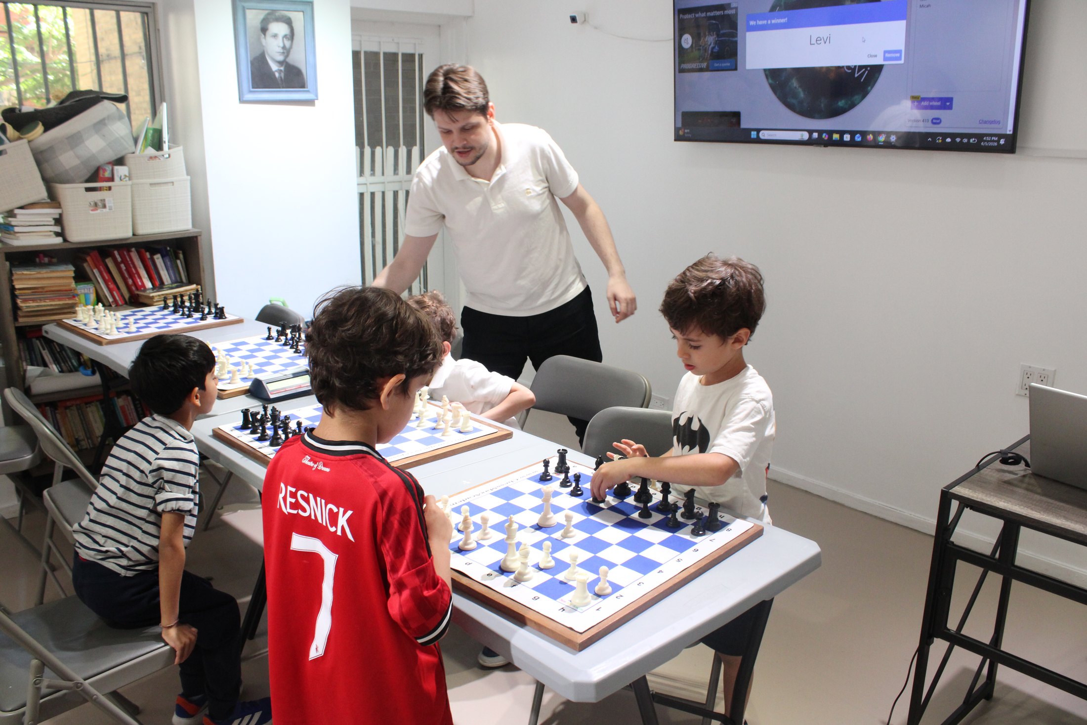 Chess Max coach helping students during an in-person group chess lesson