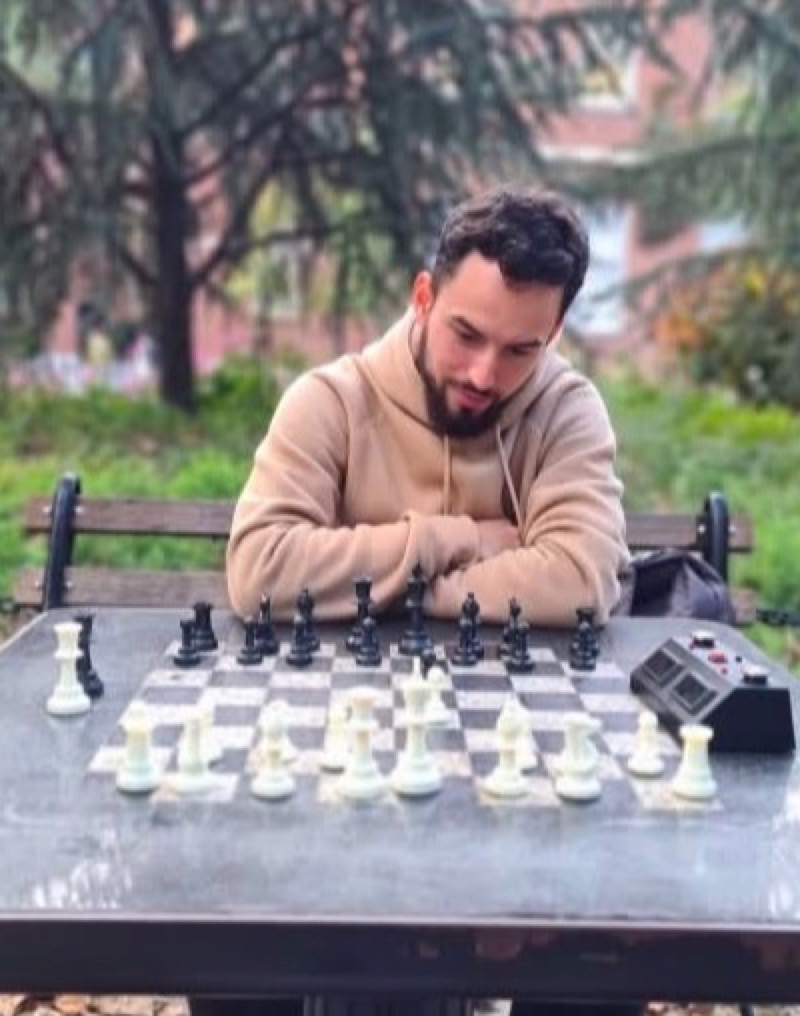 Hector Morales studying a chess position at an outdoor chess board
