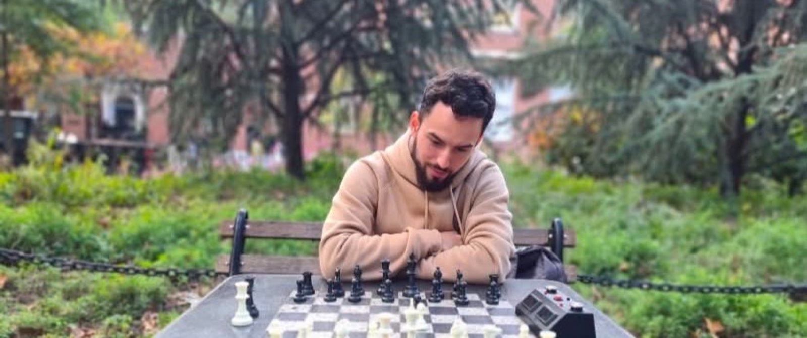 Hector Morales studying a chess position at an outdoor chess board