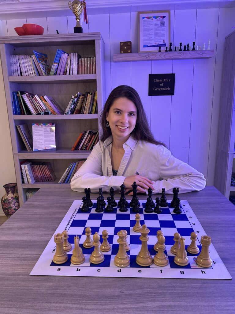 Coach Marfa Leman at a chessboard inside Chess Max Academy Greenwich