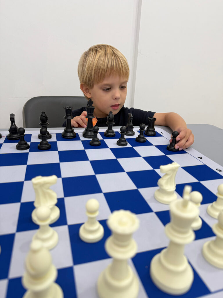 Young student concentrating on a chess position at Chess Max Academy